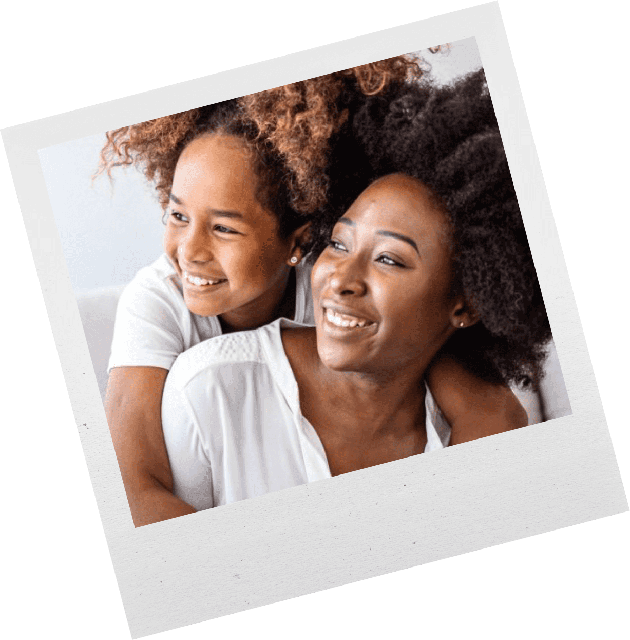 A joyful mother and daughter smiling and embracing each other.