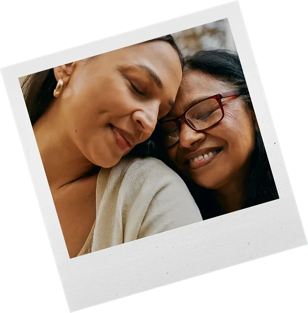 Two women sharing a warm, close moment with smiles and affection.