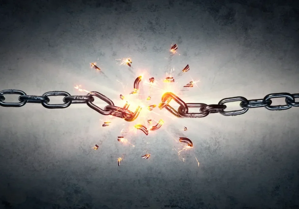 Chain breaking apart with sparks and fragments flying.